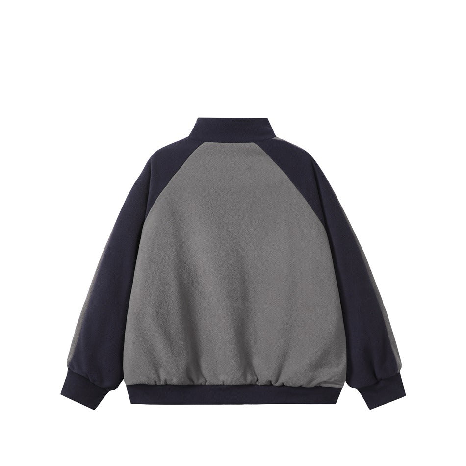 Back of a gray jacket with dark navy raglan sleeves, a stand collar, and matching ribbed cuffs and hem.