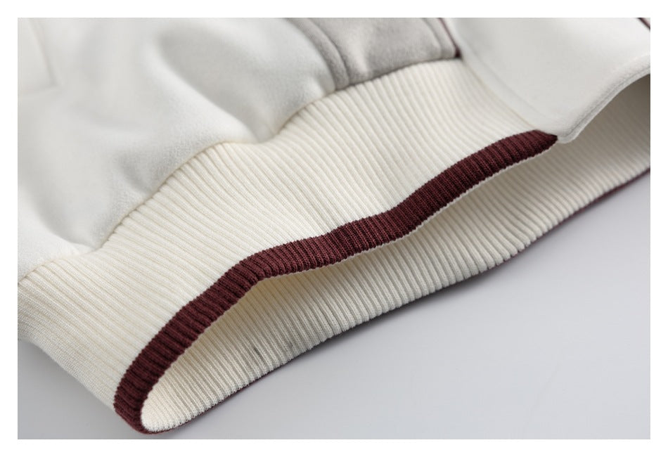 Close-up of the ivory ribbed jacket hem with a burgundy stripe.