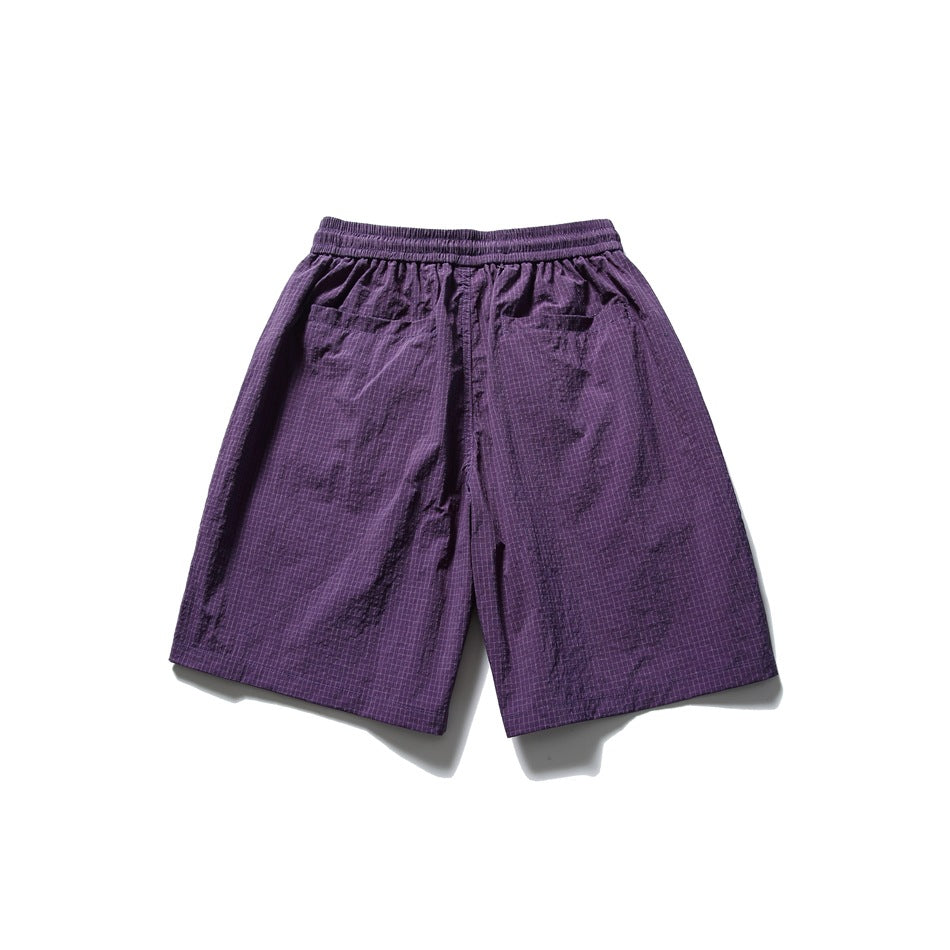 Back view of purple patterned shorts with an elastic waistband and two rear pockets.