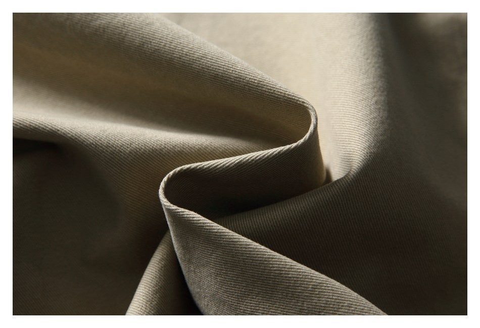 Close-up of folded taupe fabric showing a fine diagonal twill weave.