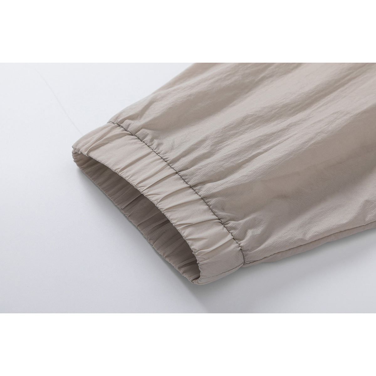 Close-up of a light taupe jacket sleeve with a gathered elastic cuff.