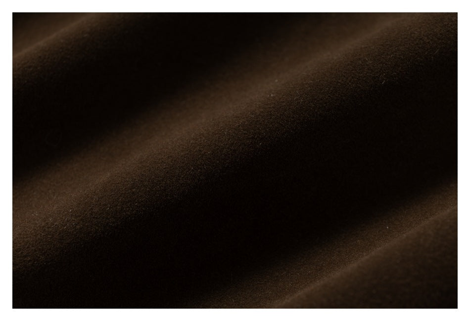 Extreme close-up of the dark brown garment fabric surface and its texture.
