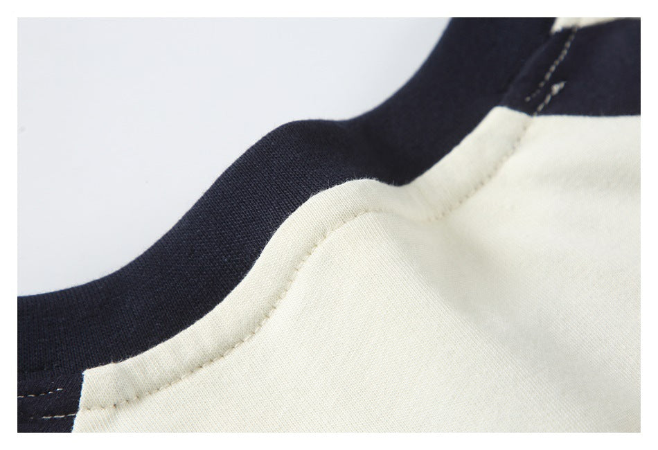 Close-up of the cream top's neckline seam against dark navy trim.