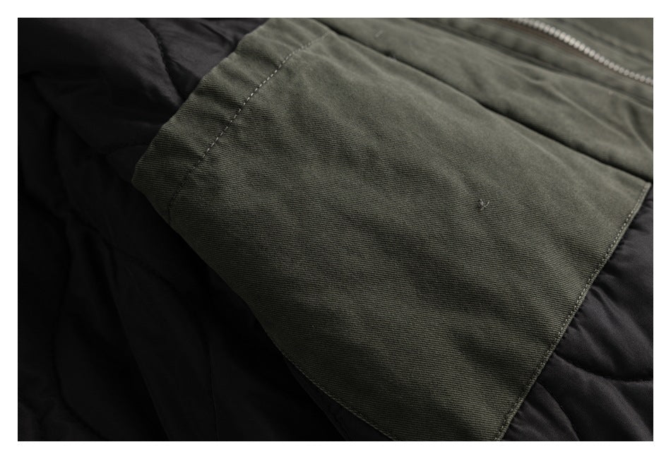 Olive-gray jacket panel folded back to reveal black quilted lining and a zipper edge.