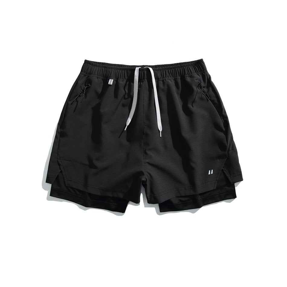 Black layered athletic shorts, front view, with white drawstrings, zip pockets, black inner shorts and a small white leg