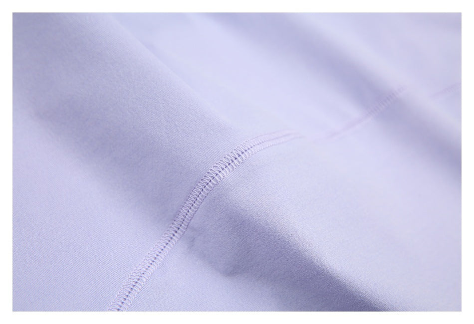 Close-up of pale lavender garment fabric with a curved overlocked seam.