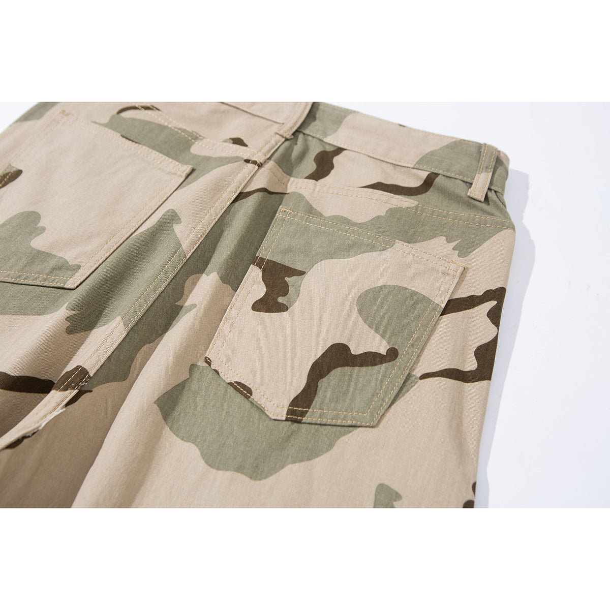Close-up of the back patch pockets and stitching on beige, olive, and brown camouflage pants.