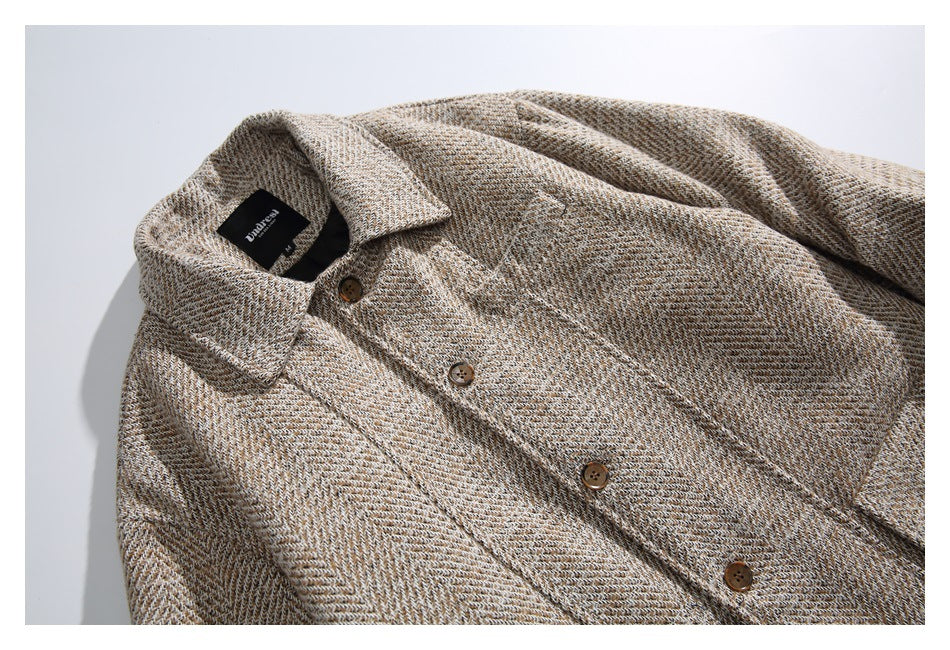 Close-up of the beige herringbone coat's collar, sewn label, and brown front buttons.