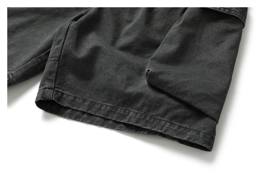 Close-up of the charcoal shorts' stitched hem and lower cargo pocket.