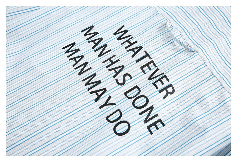 Close-up of a blue-and-gray-striped shirt printed with the black phrase “WHAT EVER MAN HAS DONE MAN MAY DO.”