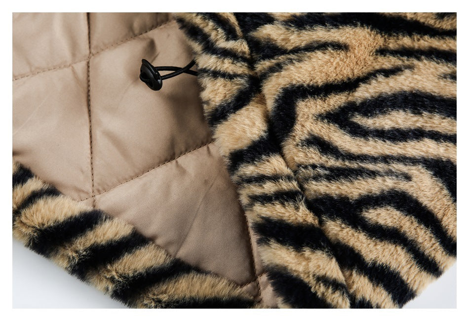 Close-up showing the tan quilted lining, black toggle cord, and tiger-striped plush exterior.