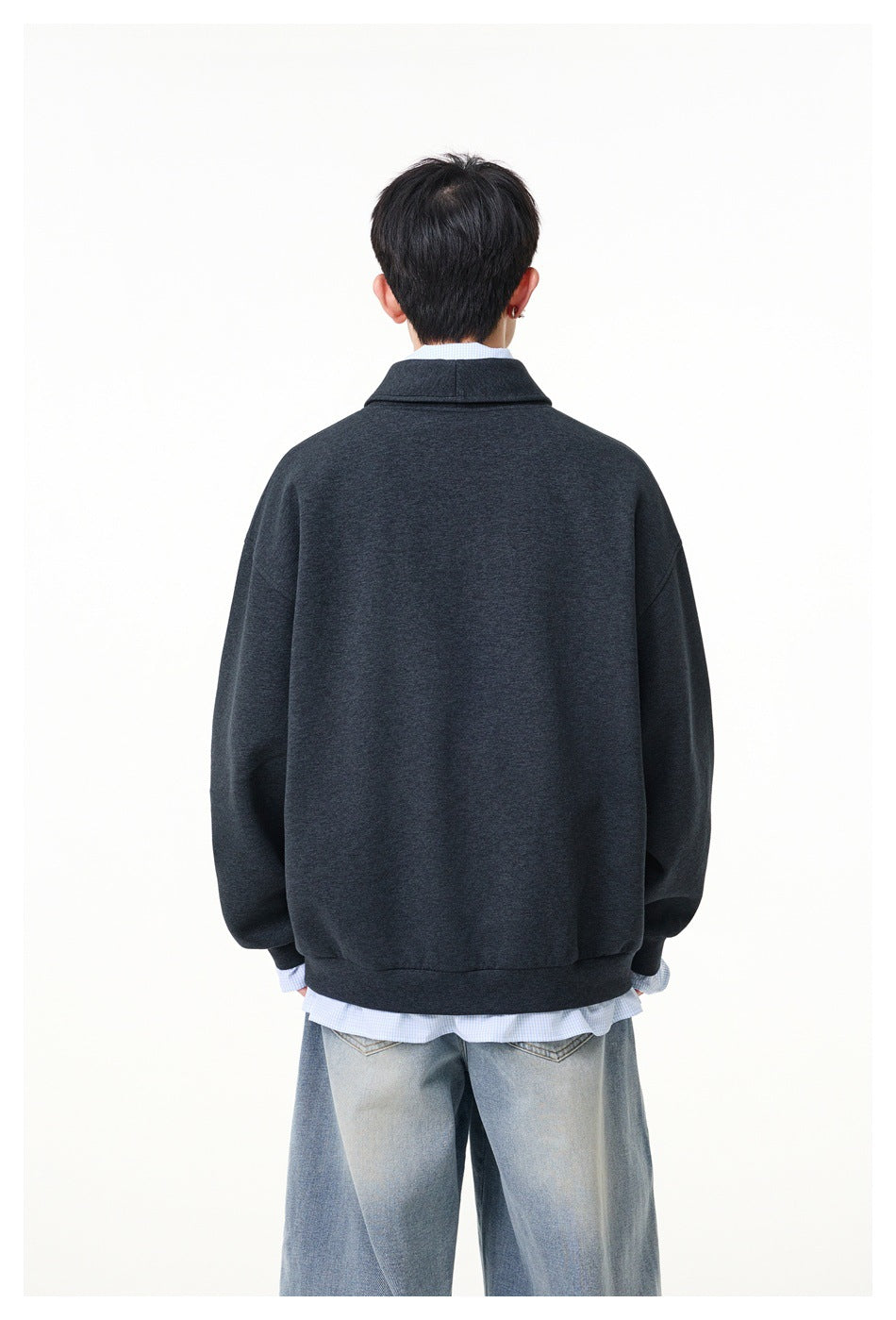 Rear view of a model wearing an oversized charcoal pullover with a wide collar and ribbed hem.