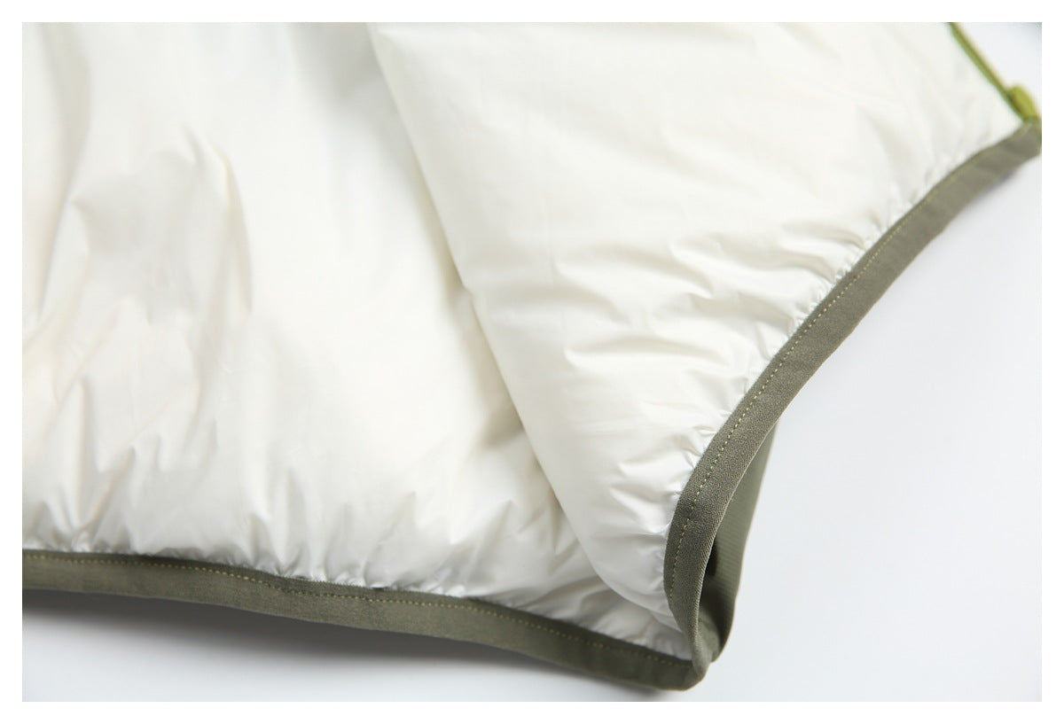 Close-up of white garment fabric with olive-gray binding and stitching along a curved edge.