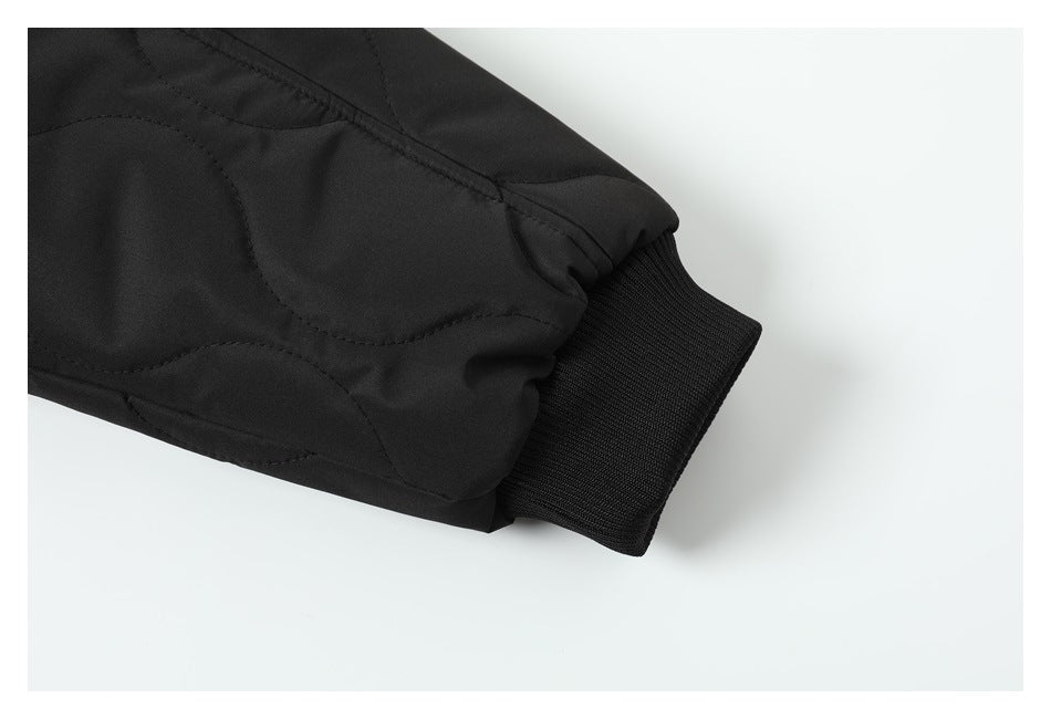 Close-up of a black jacket sleeve ending in a wide ribbed knit cuff.