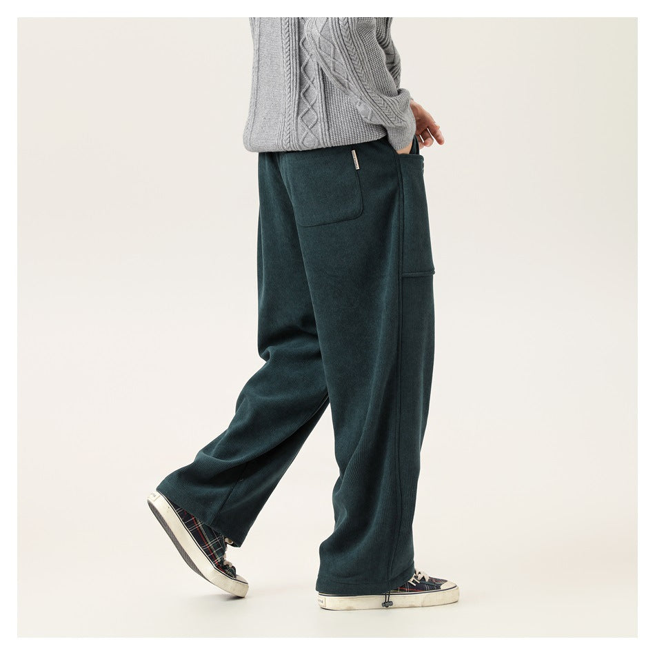 Side view of a model wearing dark teal wide-leg pants with patch pockets and drawstring hems.