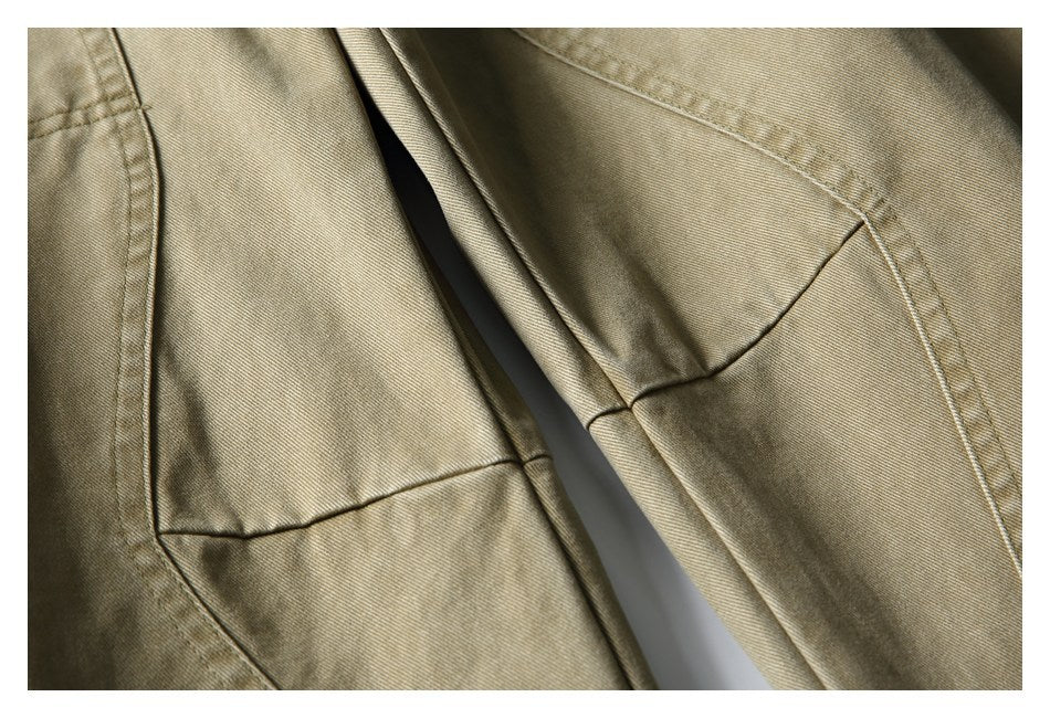 Close-up of khaki trouser legs showing curved panel seams and faded coloring.