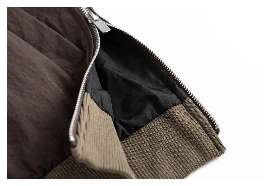 Open section of a dark brown jacket shows black lining, a silver zipper, and an olive-brown ribbed hem.