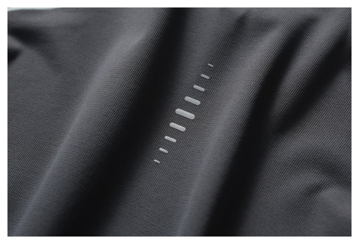 Macro view of reflective pale bars on textured dark gray fabric.