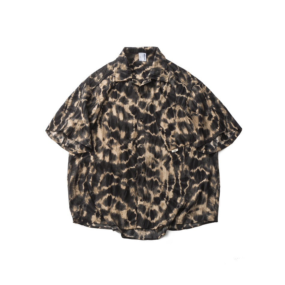 Flat-lay front of a short-sleeve leopard-print button-up shirt in black and tan with a chest pocket