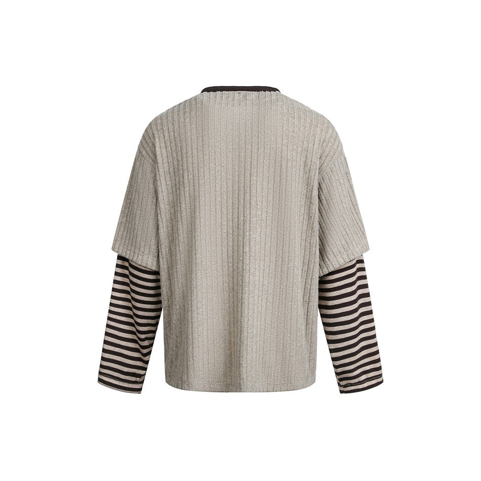 Back view of a gray ribbed short-sleeve top layered over dark brown and beige striped long sleeves.