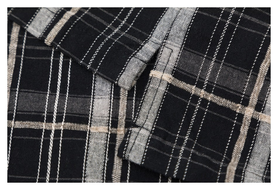 Close-up of a black plaid shirt showing the front placket and pocket stitching.