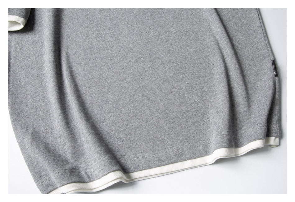 Close-up of the gray shirt's hem with a white layer showing beneath it.