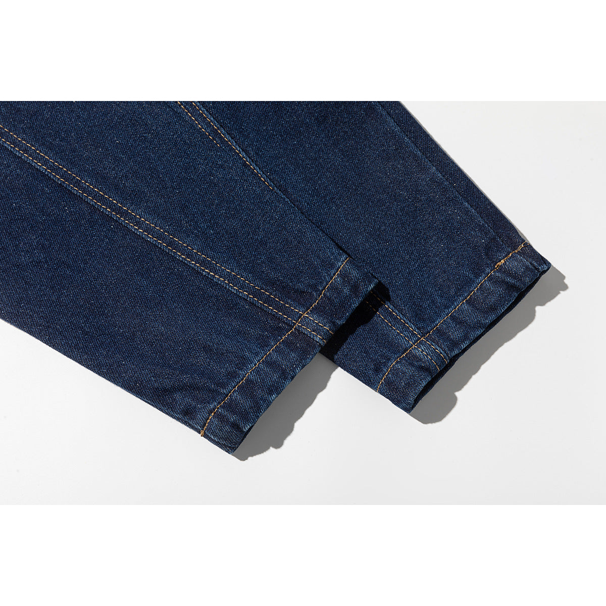 Close-up of the dark blue denim jacket's stitched sleeve cuffs and hems.
