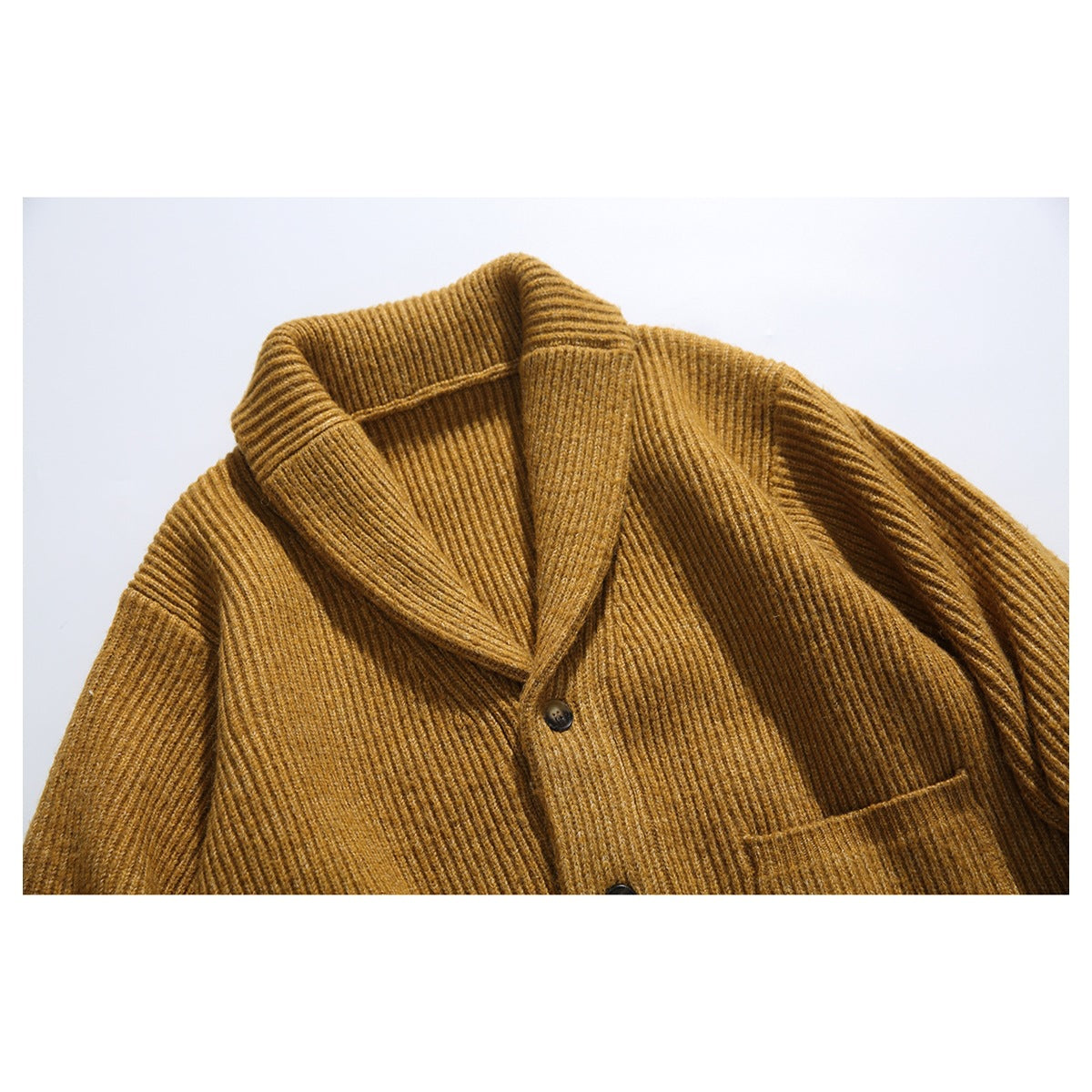 Close-up of a mustard-brown ribbed cardigan with a shawl collar, dark buttons, and a front pocket.
