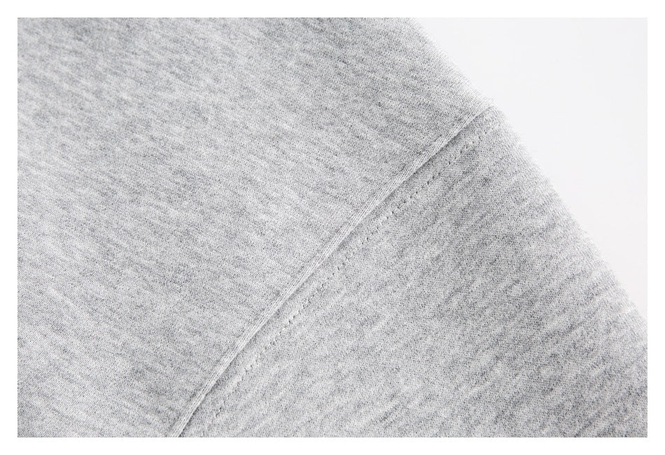 Close-up of the shoulder seam on a heather-gray sweatshirt.
