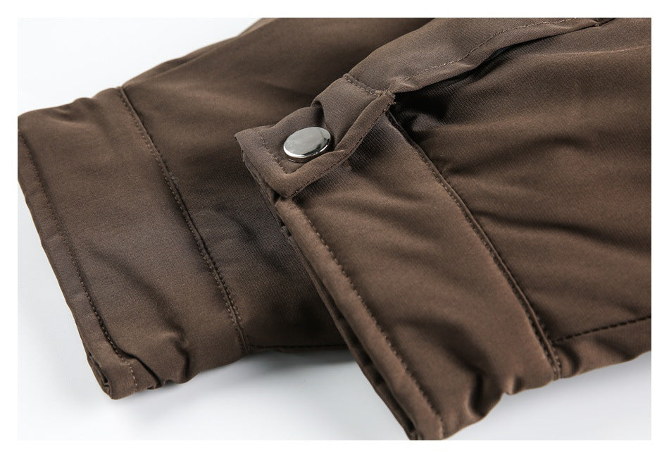 Close-up of a brown jacket sleeve tab with a silver snap fastener and stitched seams.