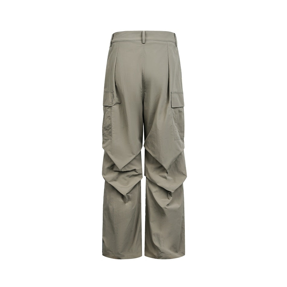 Back view of loose gray-olive cargo pants with wide legs, belt loops, and side cargo pockets on white.