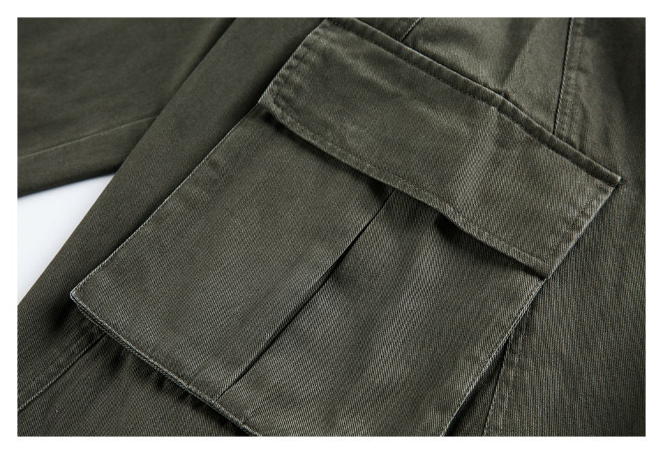 Close-up of an olive-gray cargo trouser leg with a large flap pocket.