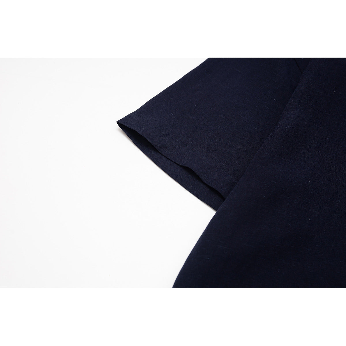 Close-up of a dark navy short sleeve and its clean hem.