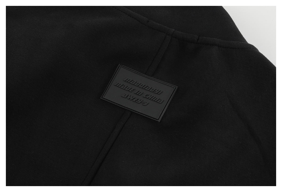 Close-up of a black garment with a raised rectangular black patch and embossed lettering.