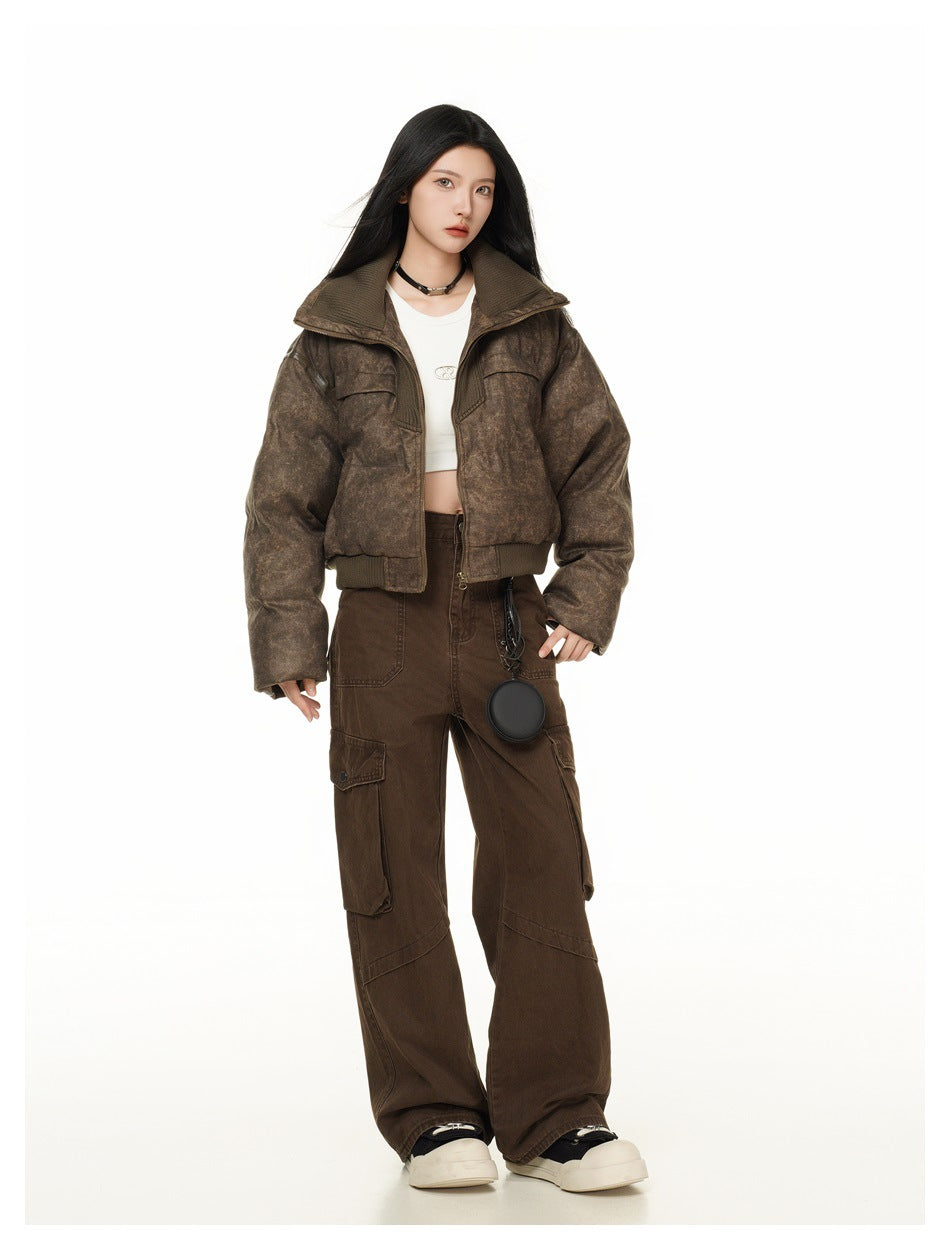 Full-length front view of a model in a mottled brown cropped jacket, white top, wide-leg brown cargo pants, and white shoes.
