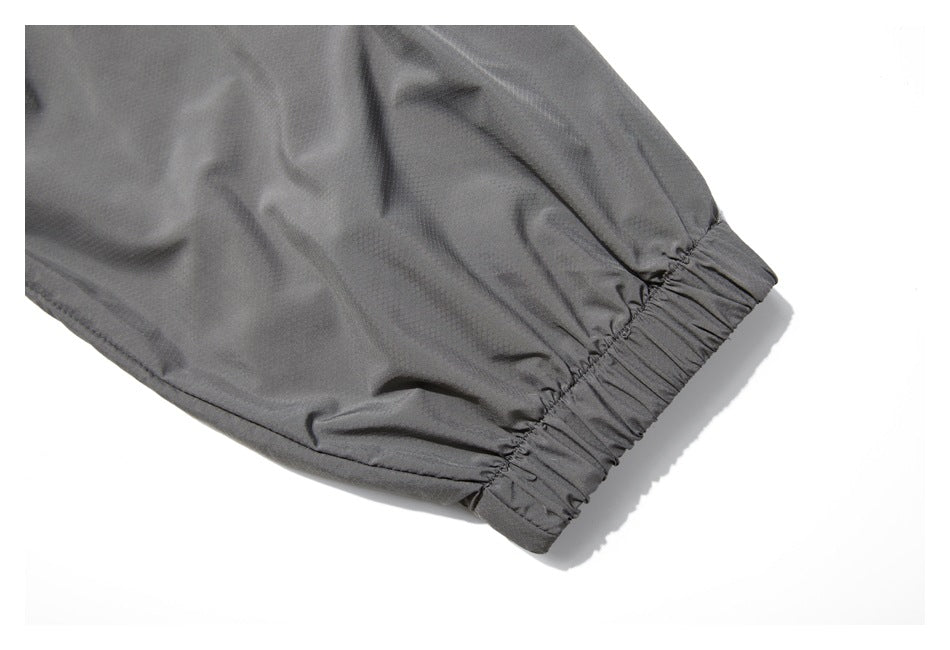 Close-up of a dark gray garment sleeve ending in a gathered elastic cuff.