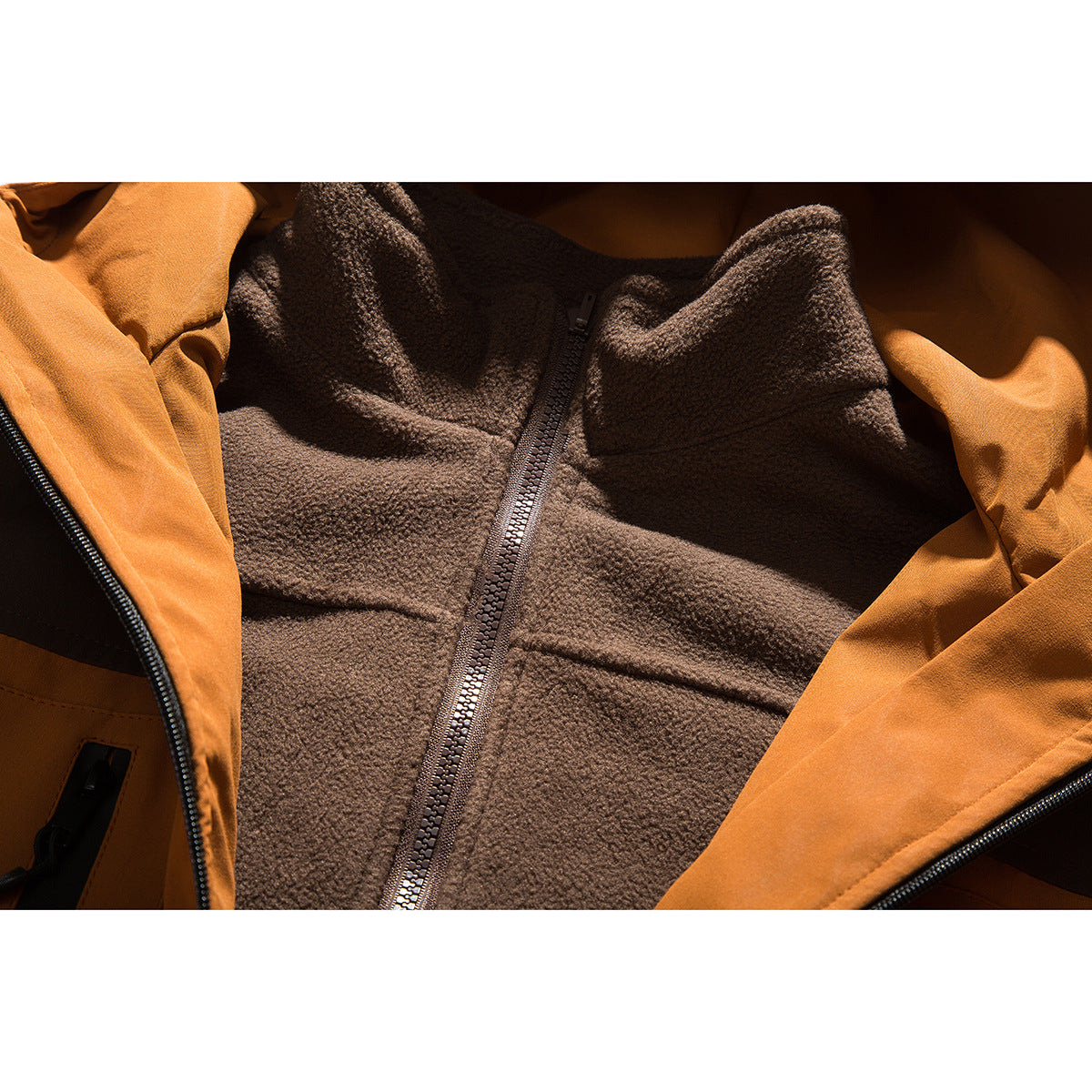 Close-up of the brown zip-front fleece lining inside an orange jacket.