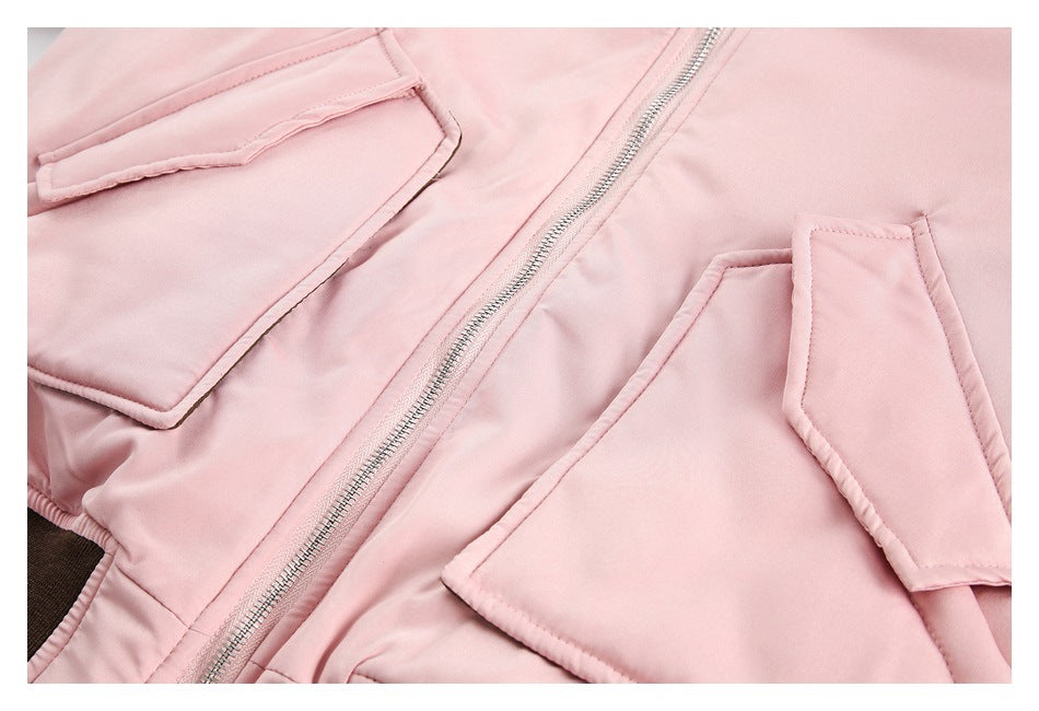 Close-up of the pale pink jacket’s front zipper and large flap pockets.