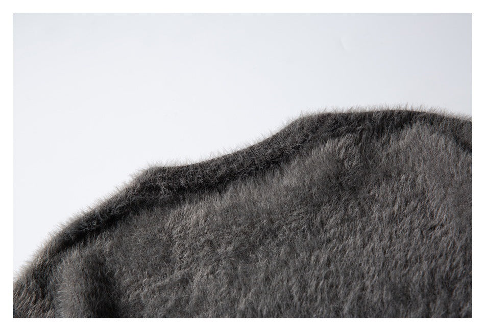Close-up of the curved shoulder area of a charcoal gray fuzzy knit garment.