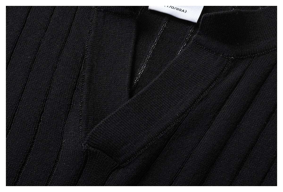 Close-up of the black knit top's V-shaped neckline and ribbed texture.