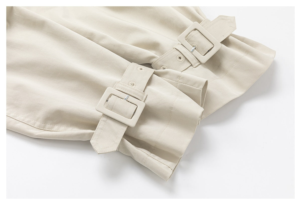 Close-up of light beige coat cuffs with adjustable matching buckle straps.