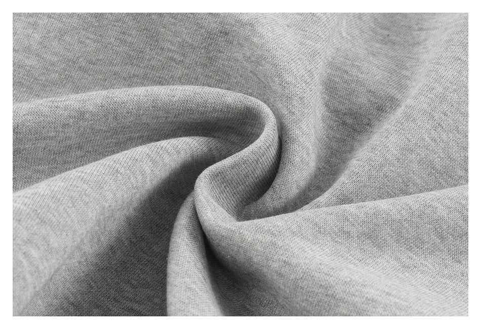 Close-up of light gray knit fabric arranged in soft folds.