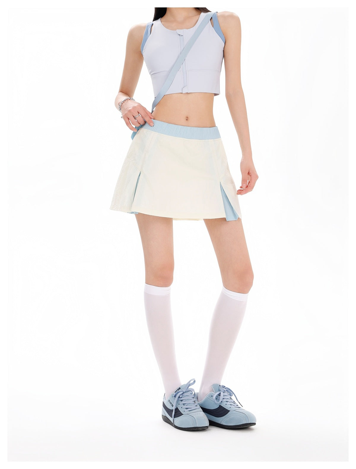 Model wearing an ivory flared skirt with a light-blue waistband and side inserts, shown from the front.