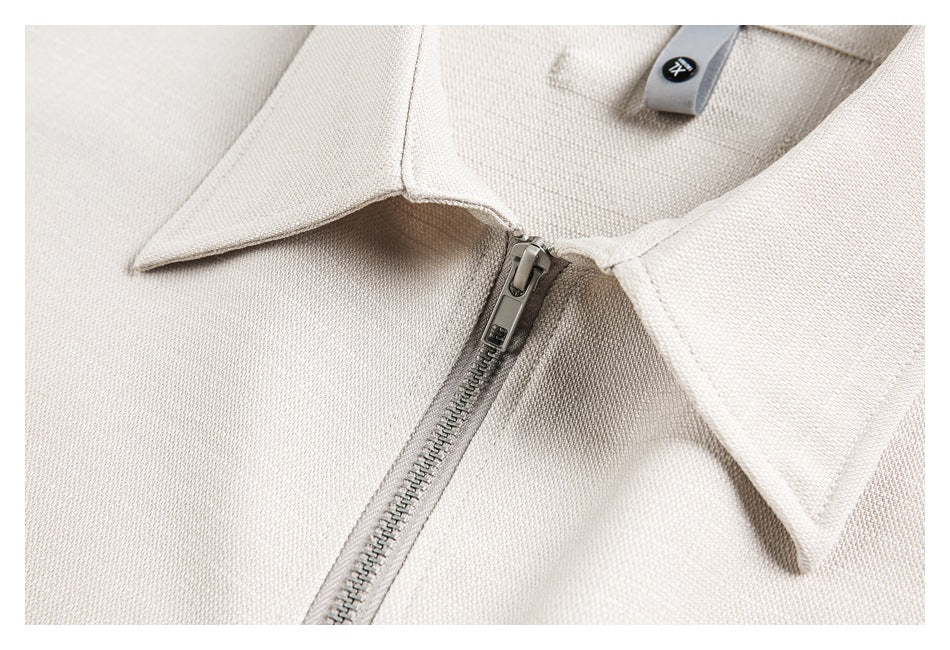 Close-up of an ivory pointed collar and silver zipper with a small sewn label.