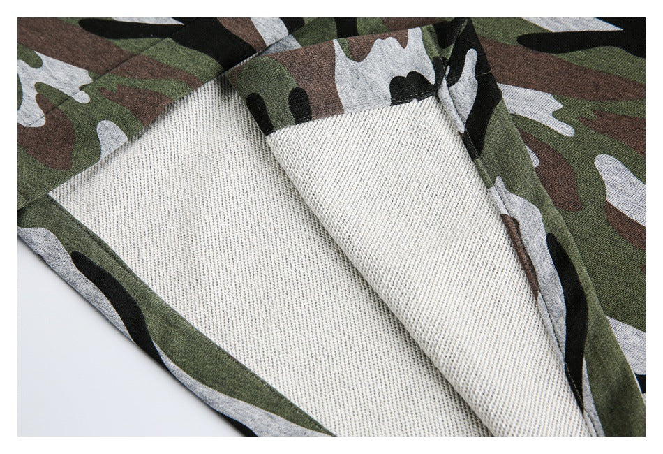 Camouflage garment turned back to show its pale textured inner surface and stitched edge.