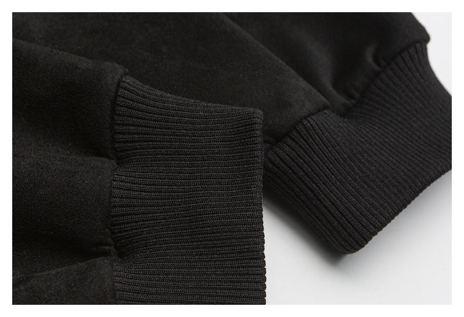 Close-up of a black sweatshirt sleeve and its wide ribbed cuff, with the ribbed hem visible beside it.