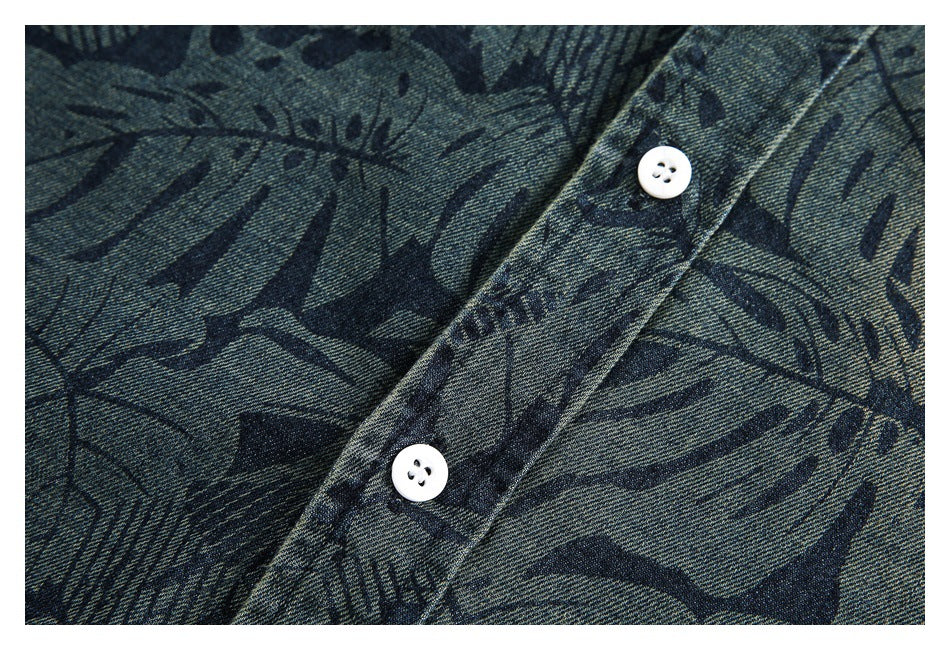 Close-up of two white buttons on a placket over blue-gray fabric with a dark abstract print.