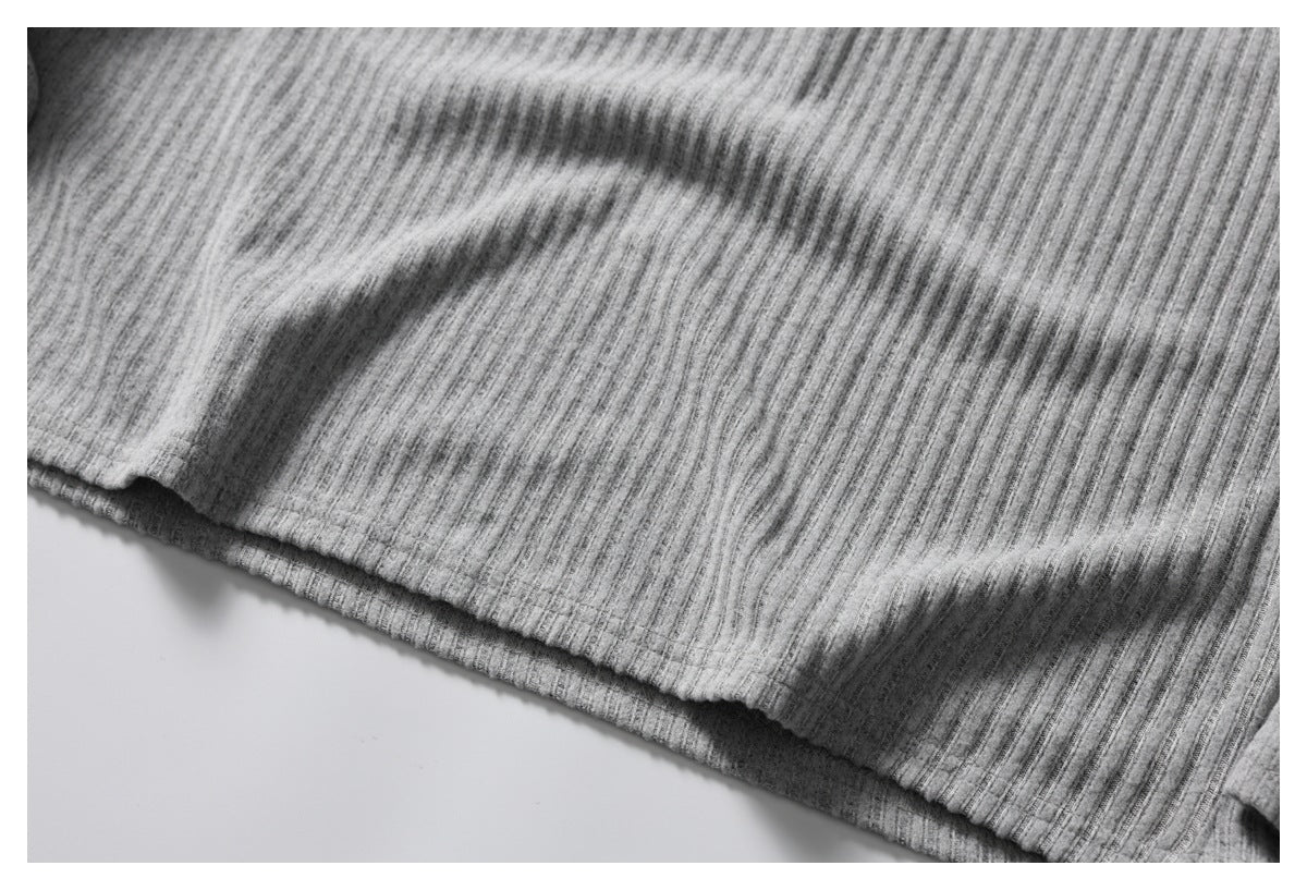 Close-up of gray ribbed knit fabric with a curved finished hem.