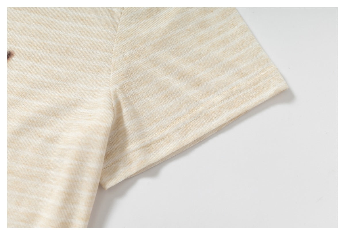 Close-up of a cream and beige subtly striped knit sleeve with a stitched hem.