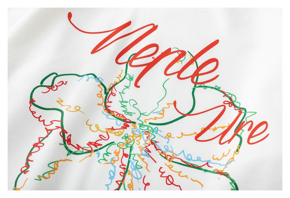 Close-up of a colorful outlined flower and large red cursive lettering printed on white sweatshirt fabric.